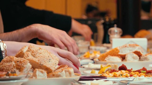 Waiter Pouring Juice into Glass with Fresh Bread and Dishes on Dining Table