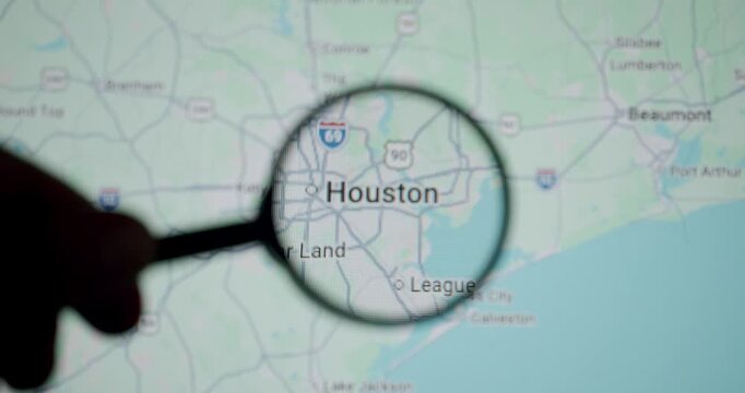 Human hand holding a magnifying glass inspecting Houston on a digital screen map, focusing on the city and its surroundings to analyze routes, geography, or plan a trip with precision