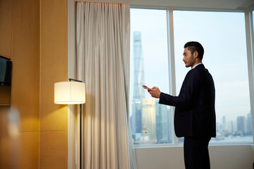 Businessman using smartphone in Shanghai hotel room © LeNgoc