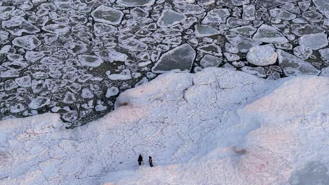 Aerial Top-Down View of Two People Walking on Frozen Ice Shelf