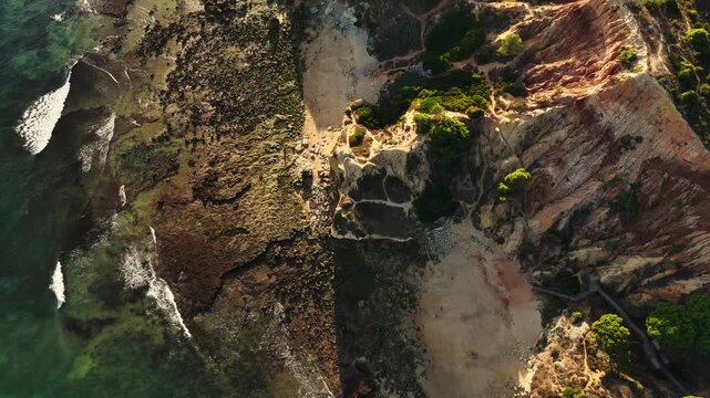 Falesia Beach, Algarve, Portugal. Golden mile beach with orange rocks, golden sand and turquoise sea. Aerial drone top view perspective. Famous travel destination in south of Portugal 
