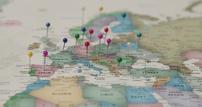 Multicolored round-headed pins marking countries and capital cities across a political map of Europe, signifying travel itineraries, international business expansion, or strategic planning