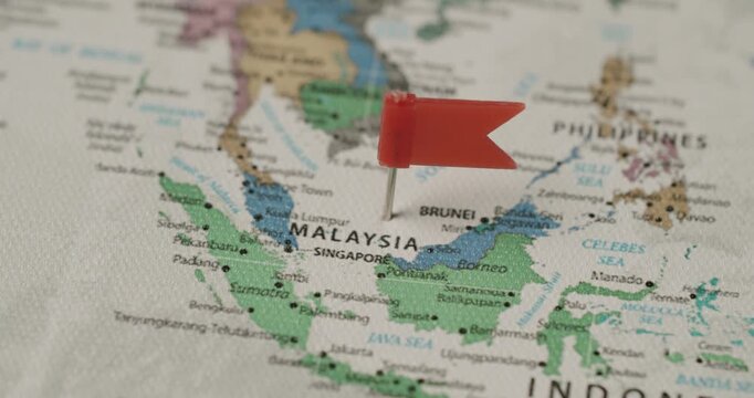 Red flag pin marking Malaysia on a world map as a travel destination, symbolizing journey planning, tourism, and exploring the geography of Southeast Asia for an upcoming vacation or adventure