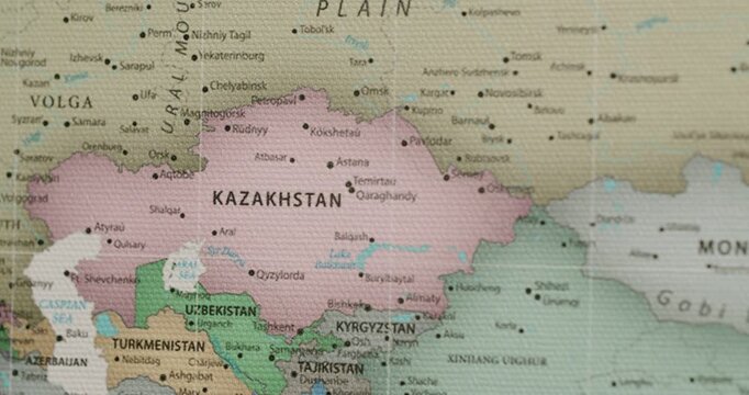 Slow camera movement over a vintage-style political map of the world showing the countries of Central Asia, focusing on Kazakhstan, Uzbekistan, Kyrgyzstan, and the Caspian Sea region