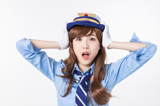 Surprised Woman in Blue Pilot or Flight Attendant Uniform Holding Hat