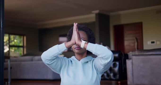 adult African woman starting palms pressing overhead lowering to chest in living room wearing watch