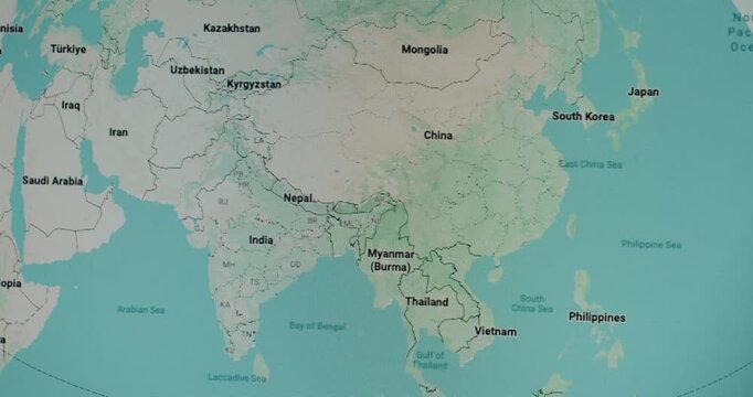 Global political map displayed on a digital screen, with the view panning smoothly from East Asia, across the Middle East, to reveal Europe and North Africa, showing countries and oceans