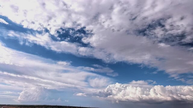 Time lapse cloudscape with billowing cumulus clouds moving across a blue sky, natural weather, atmospheric motion and scenic summer background.