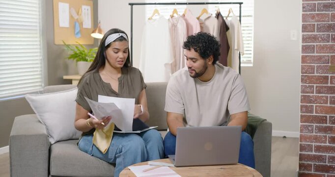 African American couple reviewing papers, woman showing swatches on couch, selecting fabrics