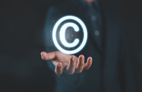 Copyright protection concept with glowing copyright symbol in hands represent intellectual property rights, digital ownership, legal security, content protection, and safeguarding creative assets.
