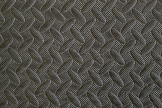 The surface texture of the puzzle mat or EVA foam floor mat is gray with a distinctive diagonal embossed pattern.