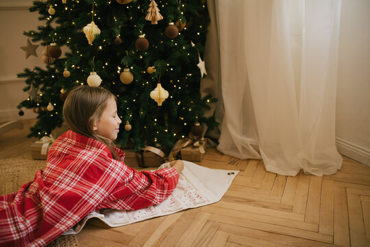 Cute 7-years old girl looking for a present in her Christmas advent calendar.