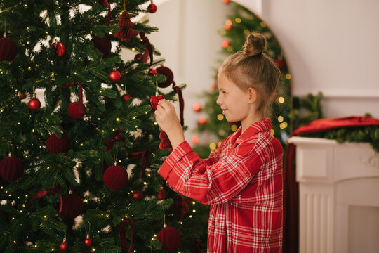 Cute 7-years old girl decorating Christmas tree