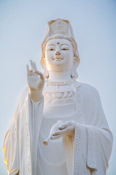 A large white Buddha statue against the sky