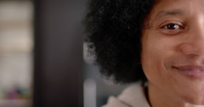 African American man in hoodie shifting neutral-to-smiling then softening at home blinds
