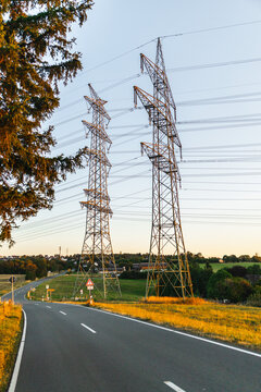 Winding Rural Road Beneath High-Voltage Pylons in Germany