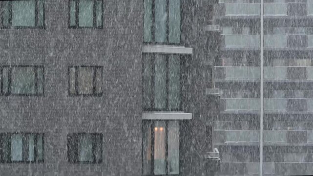 激しい雨が降る都市部のマンションの外観