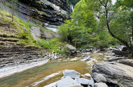  a river in the middle of cliffs with trees under a blue sky 
