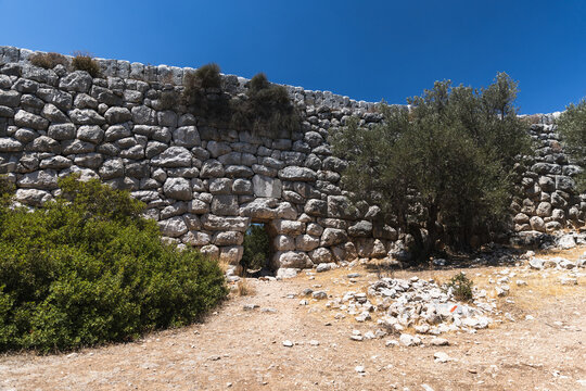 Lycian way landscape photo taken on a sunny summer day. Kas, Turkey. The supporting wall with Lycian stonework of ancient Roman Delikkemer aqueduct bridge