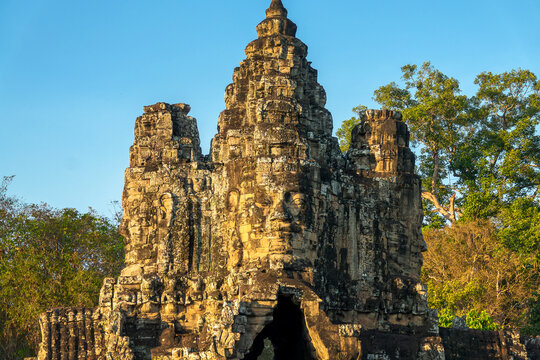 Giant stone Buddha face at Angkor Thom ancient city South gate, Angkor at sunset, Siem Reap, Cambodia