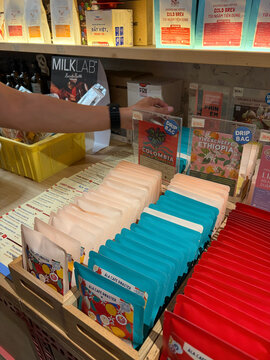 A variety of colorful paper products are displayed on wooden shelves. The colors include teal, red, and cream. 