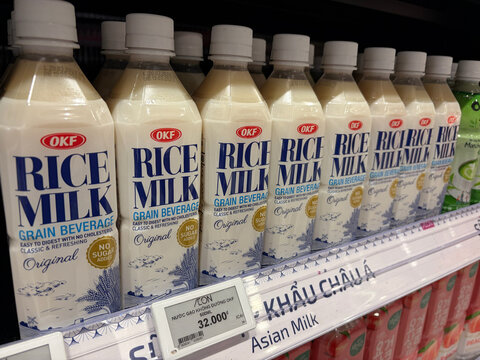 A display of rice milk cartons on a supermarket shelf. The cartons are primarily white with blue and yellow labels. Each carton is clearly labeled with 'Rice Milk' and nutritional information. 