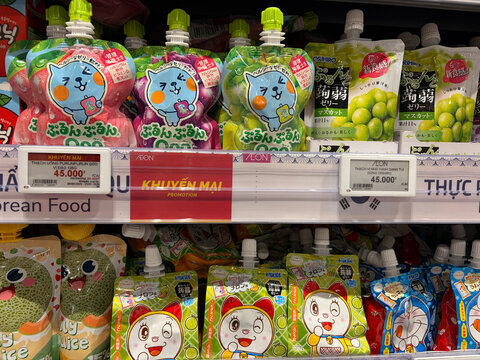 Colorful assortment of food pouches on a store shelf. Various flavors are displayed with cartoon characters on the packaging. Bright colors attract attention, creating a fun shopping experience.