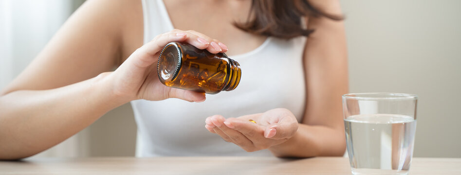 person prepare fish oil pills to her hands taking daily supplement