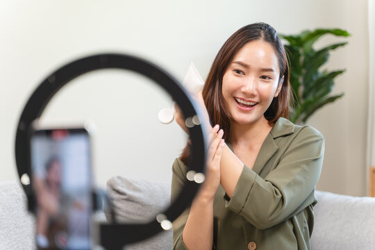 Social media influencer and marketing advertise concept, Asian young female broadcasting lives in her channel in online platform review beauty product.