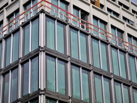 Modern Glass Office Facade Under Construction with Safety Rails and High Tech Double Glazed Windows
