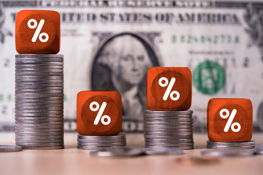 Interest rate and financial market concept with percentage symbols on stacked coins against US dollar background represent monetary policy, borrowing costs, inflation, savings and investment returns.