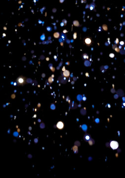 Bright sparks flying in a dark setting during a celebration with colorful lights and a festive atmosphere