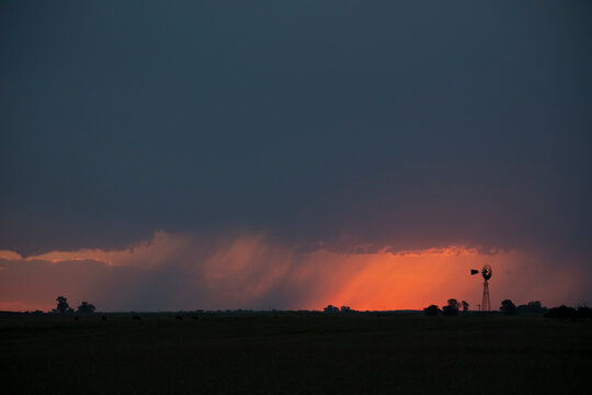 Windmill at sunset with a rain storm in the background, Pampas, Patagonia,Argentina.