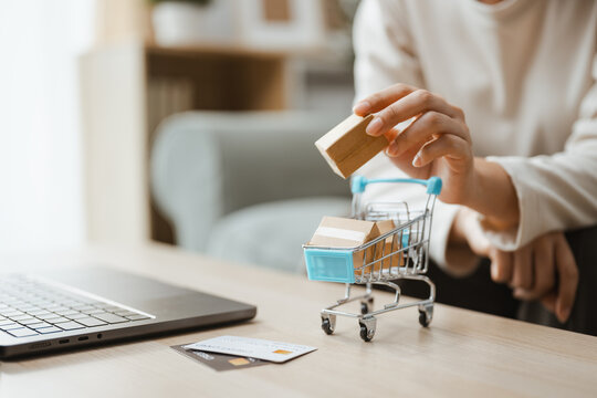 A hand moves package as parcel and add and adding and cart and shopping lead, then parcel and add and adding and cart and shopping lead the selected option on a tabletop for tomorrow in close detail.