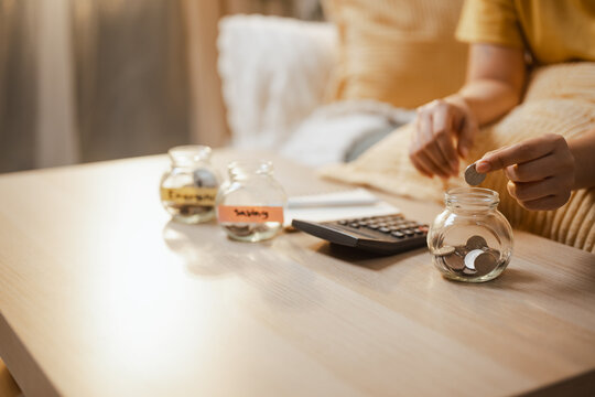 Hands sort coins into jars as savings and deposit and plan and financial and allocation lead, then savings and deposit and plan and financial and allocation lead a future reserve at a desk today now.