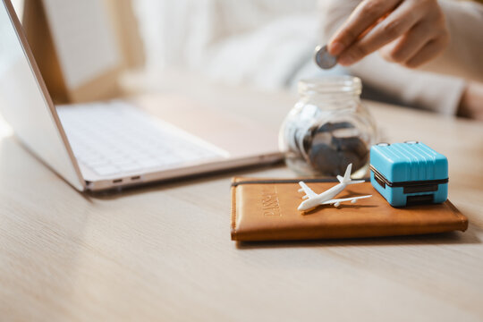 A coin rests by jar as travel and savings and vacation and fund and airplane lead, then travel and savings and vacation and fund and airplane lead the future goal at a desk for tomorrow next weekend.