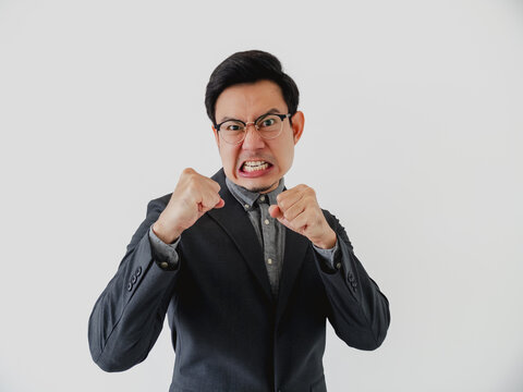 Angry Asian Businessman Clenching Fists, Gritting Teeth, Expressing Frustration and Aggression on White Background