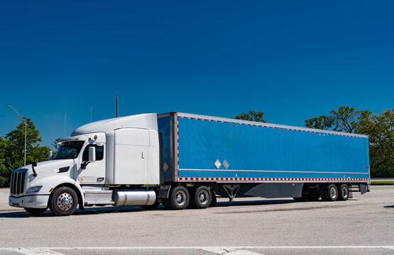 American style truck. Transport concept. Road freight cars. Trucking with semitruck vehicle. Semi truck in America. Freightliner trailer transportation. Rig truck semi trailer hauling