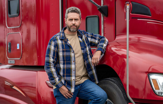 Handsome man driver in front of truck. Trucking owner. Truck driver. Man trucker driver near lorry truck. Transportation vehicles. Semi trucks vehicle. Hispanic man trucker. Transport industry