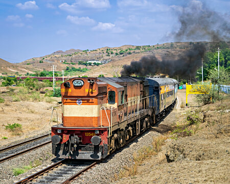 An Indian Railways WDG-3A diesel locomotive chugs and emits thic
