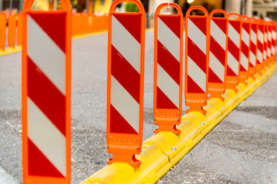 Anti parking bollard in city. Row of barriers on road separating traffic zone. Crosswalk for pedestrians. Crosswalk bollard. Road traffic delineator. Lane separator bollard. Traffic bollard sign