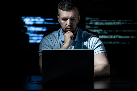 Programmer works with laptop and server. Programmer writes code on code screen. Programmer monitors network and system control. Programmer protects database and digital information.