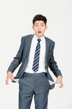 Shocked businessman showing empty pockets and financial trouble