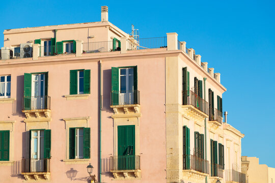 The architectural exterior features classic balconies and traditional window treatments on a historic residential structure in Mediterranean style