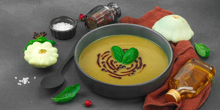 Creamy pattypan squash soup, garnished with basil and balsamic glaze, served in a trendy bowl