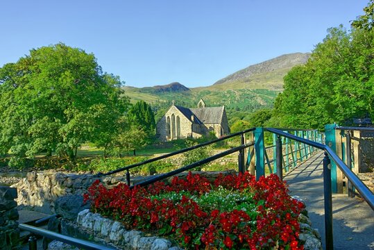 The historic Church of St Mary in the picturesque village of Beddgelert, set against the scenic mountains of Snowdonia (Eryri) National Park, North Wales, UK.