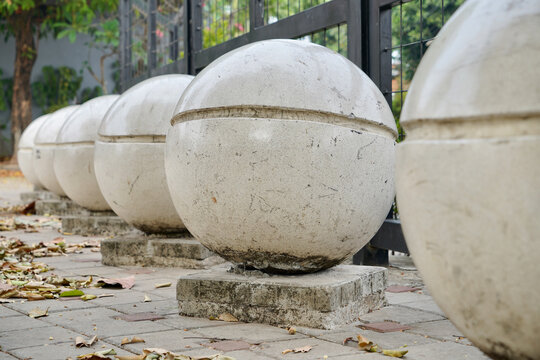 Asymmetrical Concrete Bollard Sphere with Crack
Concrete bollard sphere with asymmetrical horizontal groove line and visible base crack on urban sidewalk paving block, ideal for infrastructure