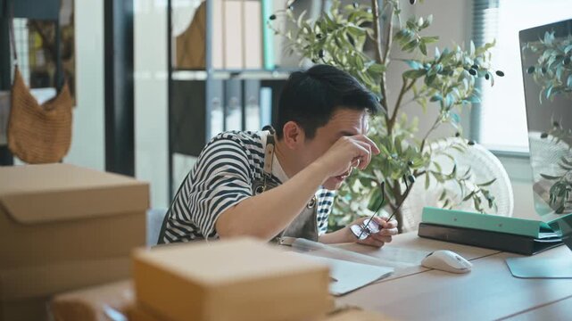Asian small business owner celebrating online order success in home office