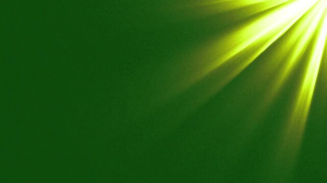 Vibrant yellow spotlight rays on green screen background . Glowing sunburst flash and lens flare light animation, sunrays light effect, sunshine footage for video editing.