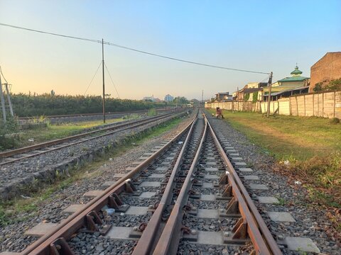Railway tracks extending towards the horizon with junction switches at sunset.